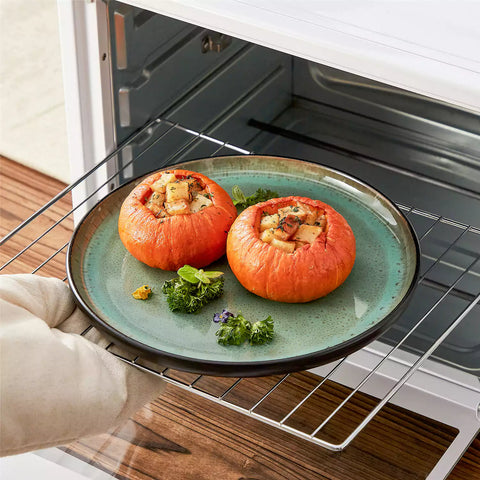 Assorted dishes with soup - dessert - and fruit salad on rustic wooden table - Amber 16-Piece green stoneware dinnerware set with plates and bowls by vancasso