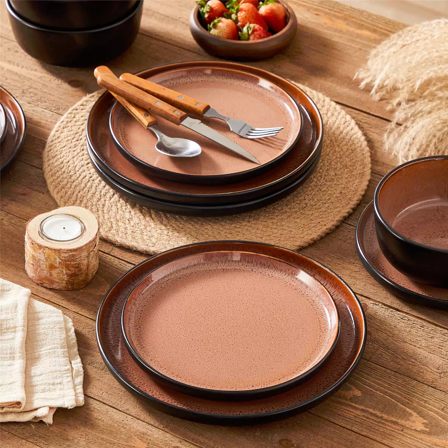 Rustic dining table with Amber 12-piece stoneware dinnerware in farmhouse red - featuring reactive glaze plates - bowls - and utensils by vancasso