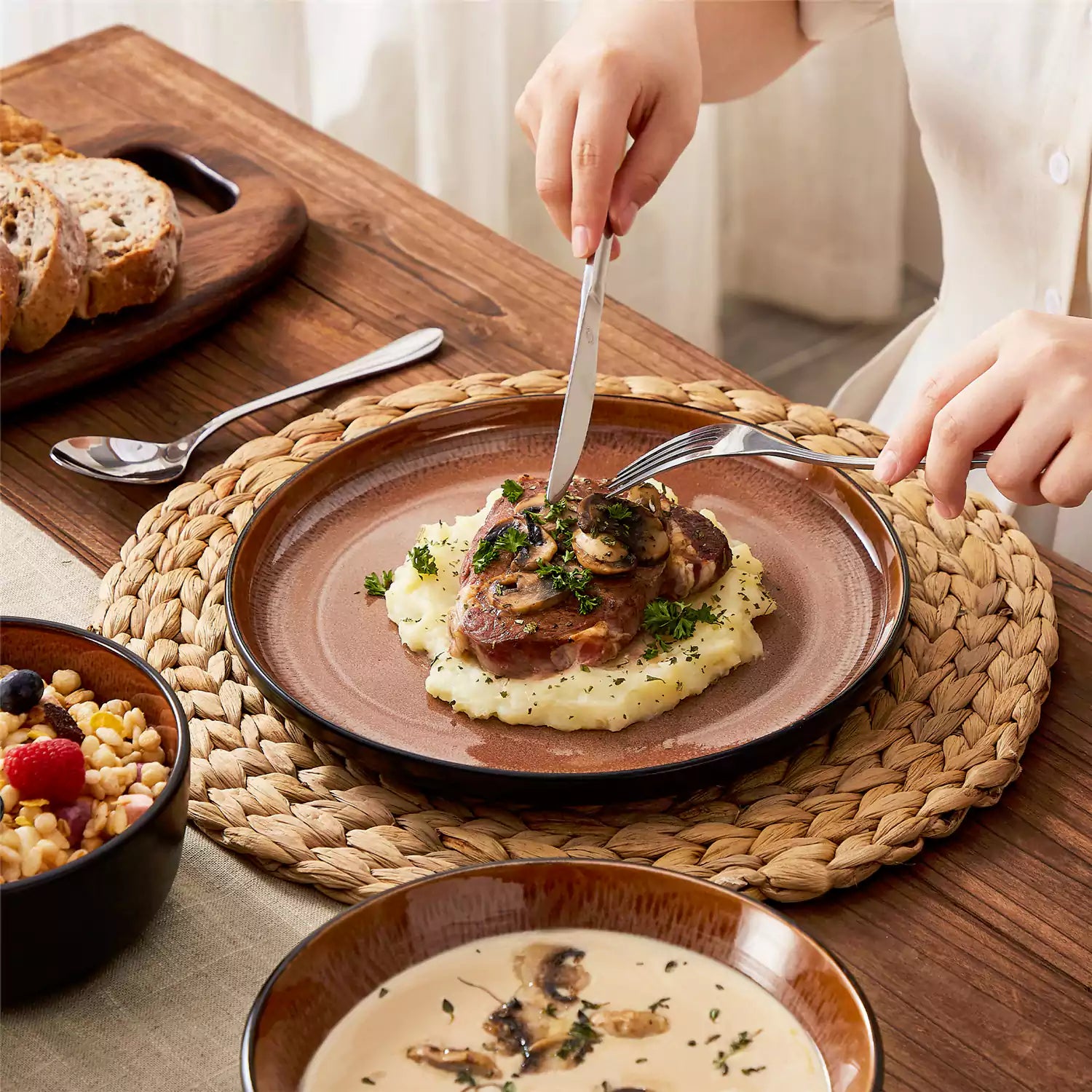 Assorted dishes with soup - dessert - and fruit salad on rustic wooden table - Amber 16-Piece red stoneware dinnerware set with plates and bowls by vancasso