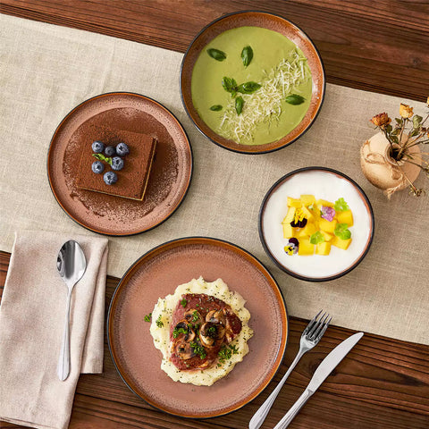 Assorted dishes with soup - dessert - and fruit salad on rustic wooden table - Amber 16-Piece red stoneware dinnerware set with plates and bowls by vancasso