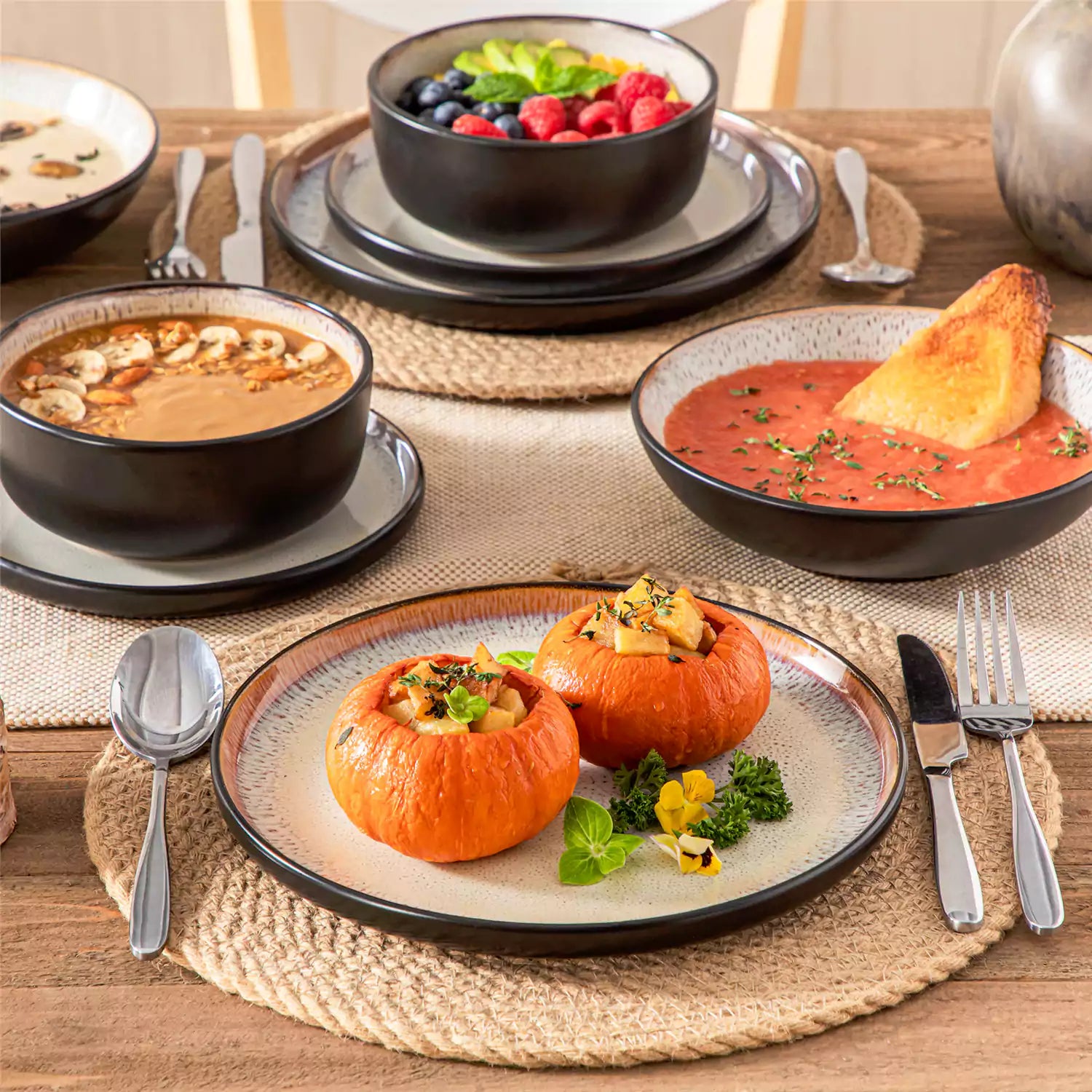 Assorted dishes with soup - dessert - and fruit salad on rustic wooden table - Amber 16-Piece beige stoneware dinnerware set with plates and bowls by vancasso