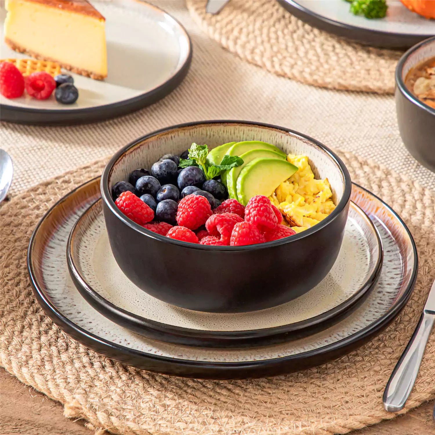 Assorted dishes with soup - dessert - and fruit salad on rustic wooden table - Amber 16-Piece beige stoneware dinnerware set with plates and bowls by vancasso