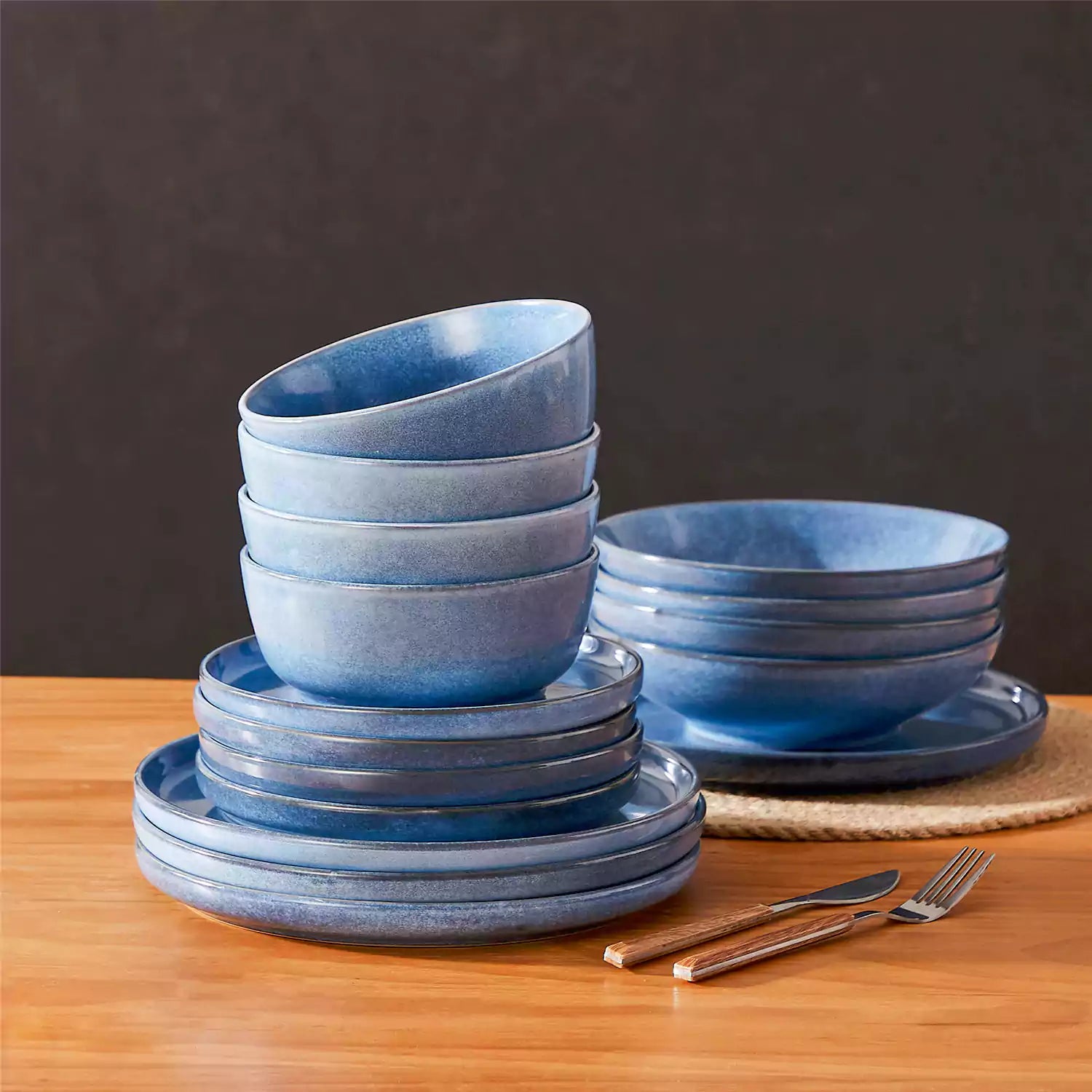 Handcrafted blue stoneware with reactive glaze on woven placemats - perfect for farmhouse tables