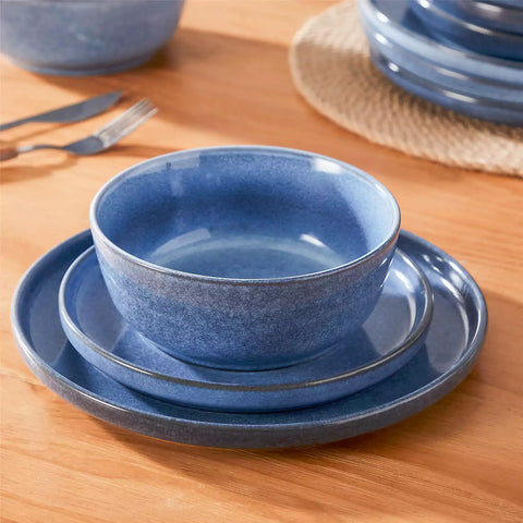 Handcrafted blue stoneware with reactive glaze on woven placemats - perfect for farmhouse tables