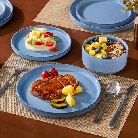 Anya 12 piece straight edge stoneware dinner set in blue with food on a rustic farmhouse wooden table with a side salad and cutlery