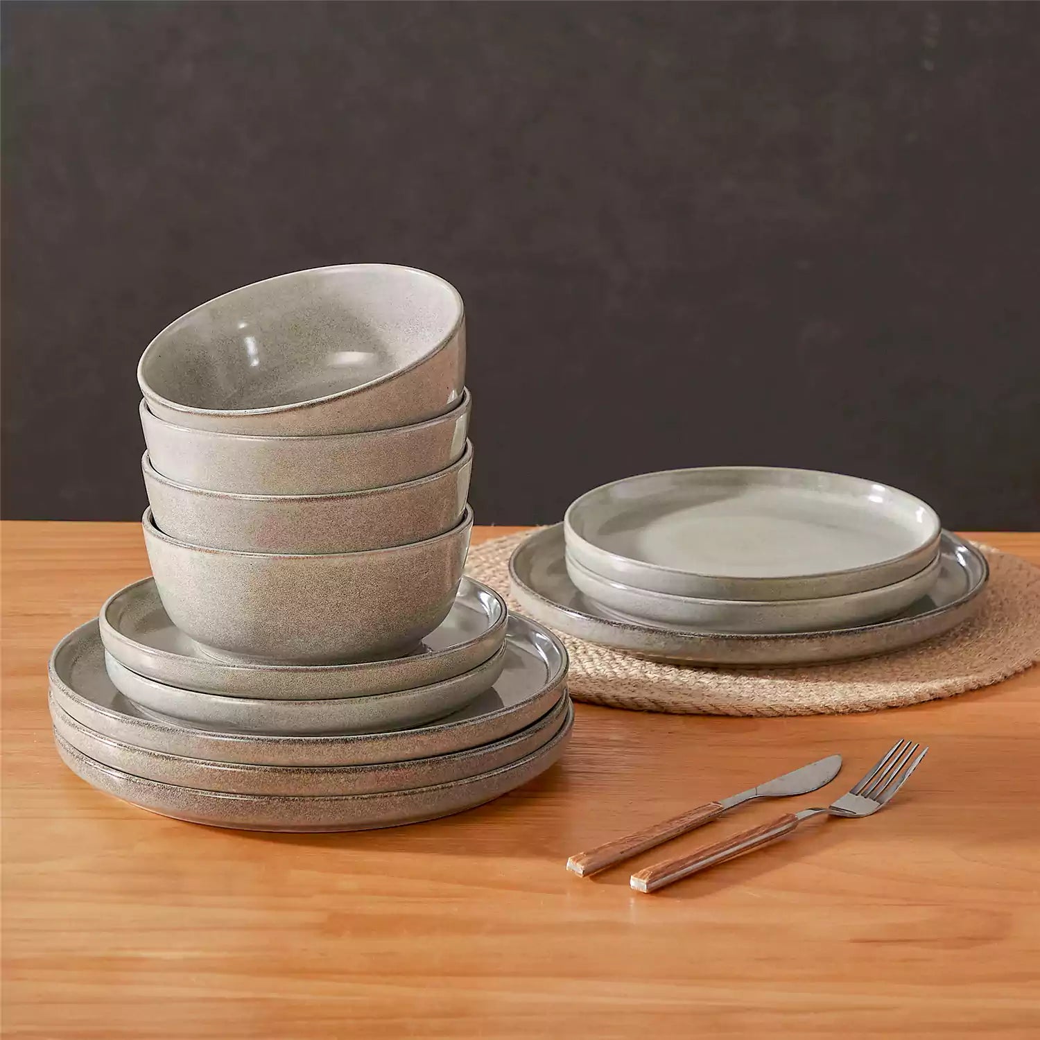 Brown stoneware plates and bowls with reactive glaze on farmhouse wooden table with woven placemats