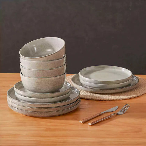 Brown stoneware plates and bowls with reactive glaze on farmhouse wooden table with woven placemats