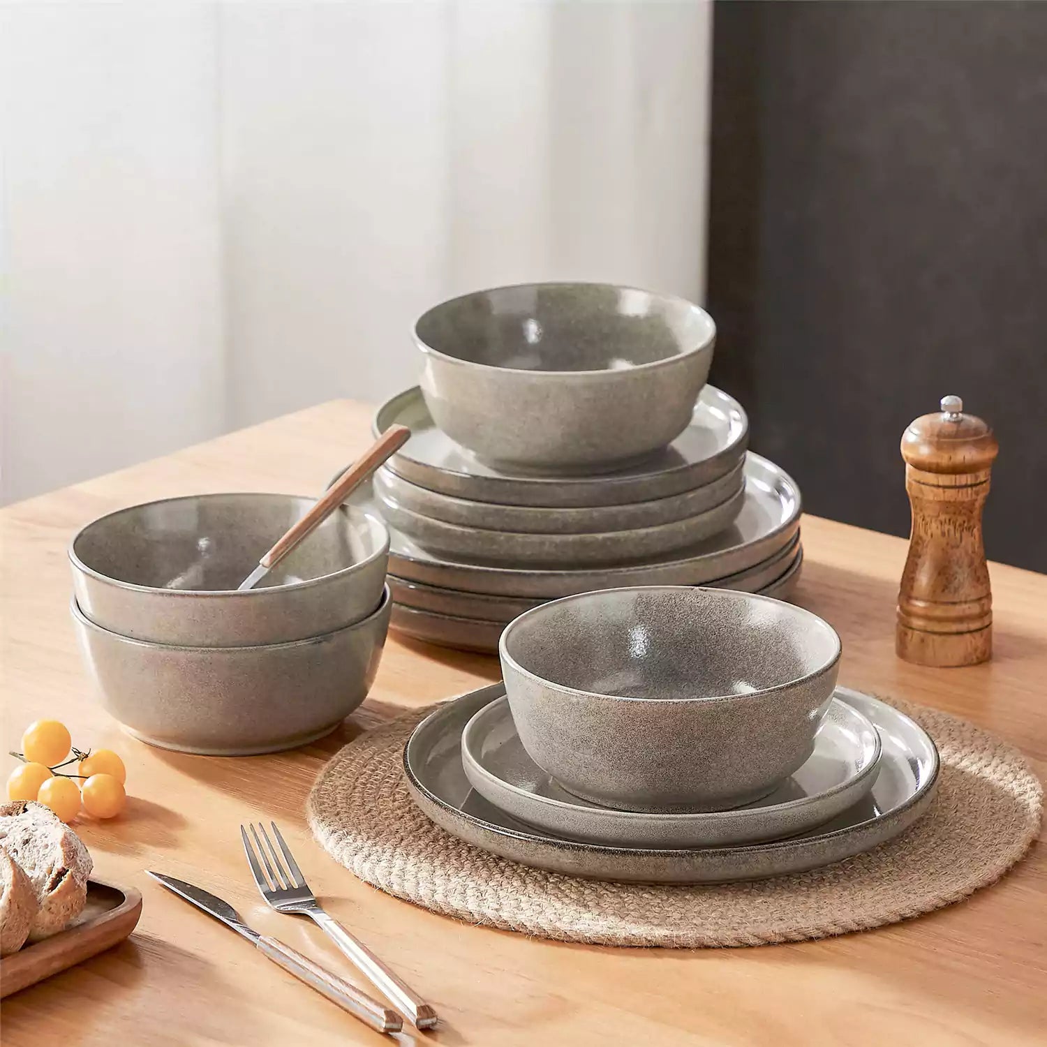 Brown stoneware plates and bowls with reactive glaze on farmhouse wooden table with woven placemats