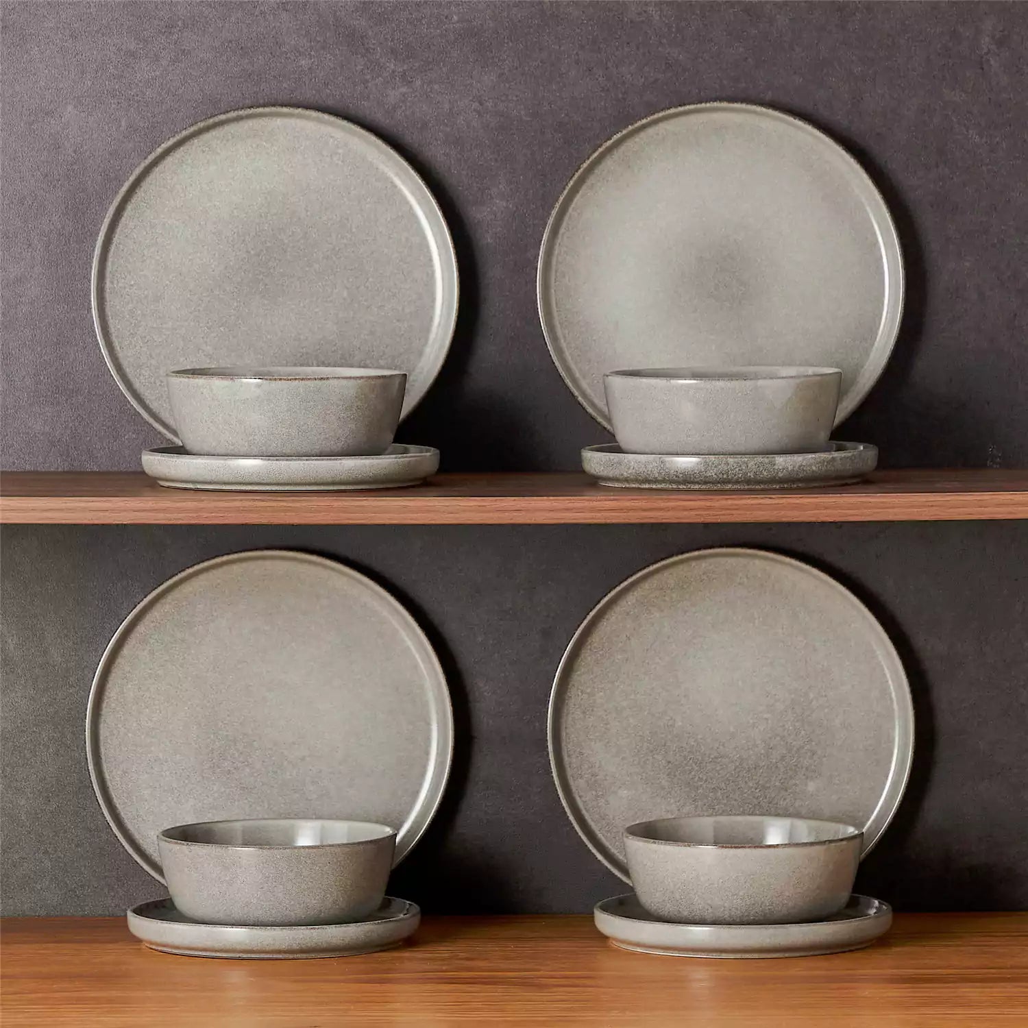 Brown stoneware plates and bowls with reactive glaze on farmhouse wooden table with woven placemats