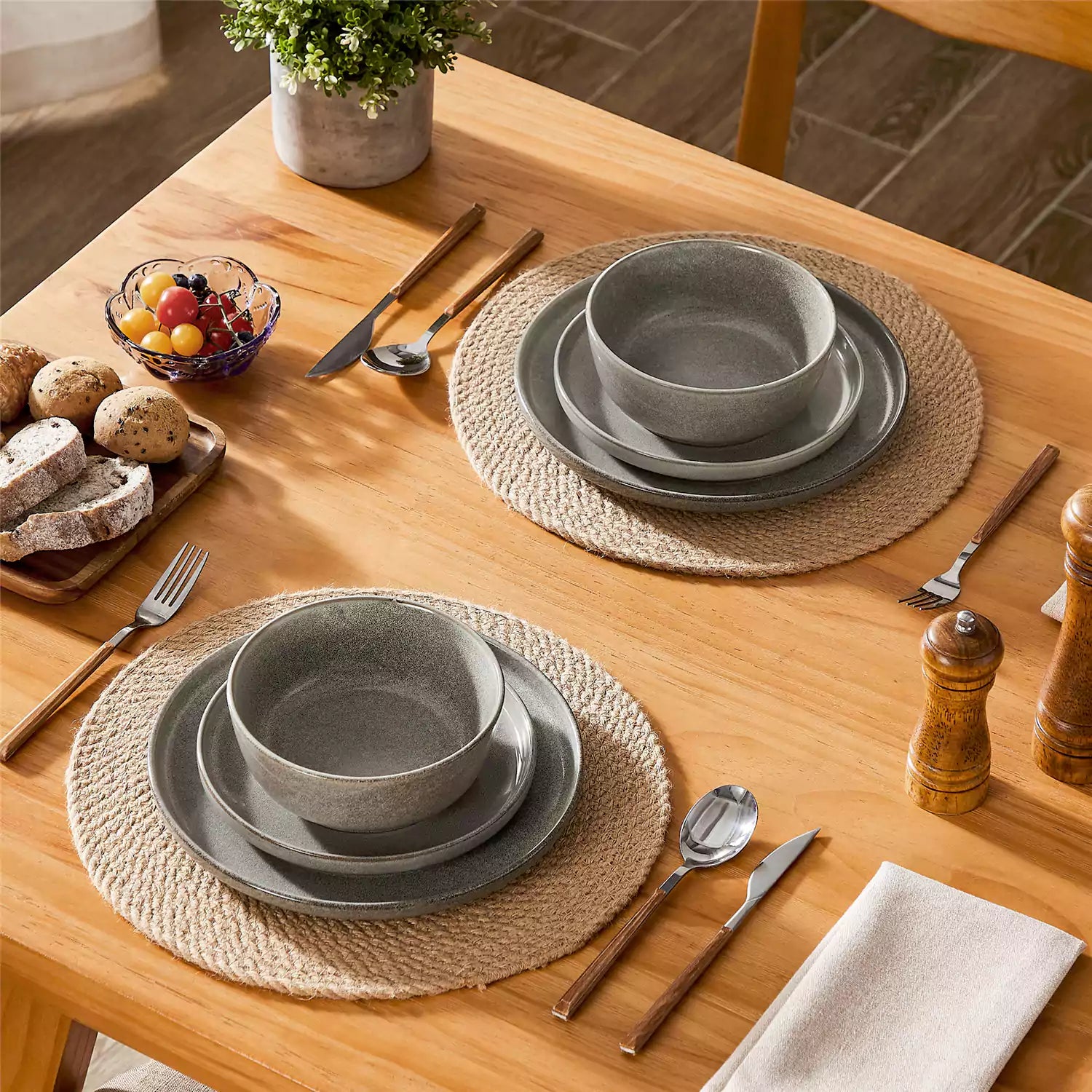 Brown stoneware plates and bowls with reactive glaze on farmhouse wooden table with woven placemats