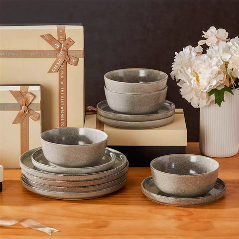 Brown stoneware plates and bowls with reactive glaze on farmhouse wooden table with woven placemats