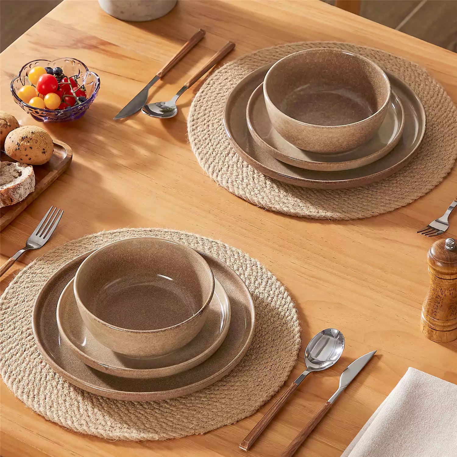 Caramel stoneware plates and bowls with reactive glaze on farmhouse wooden table with woven placemats