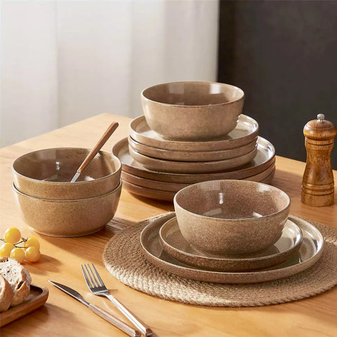 Caramel stoneware plates and bowls with reactive glaze on farmhouse wooden table with woven placemats