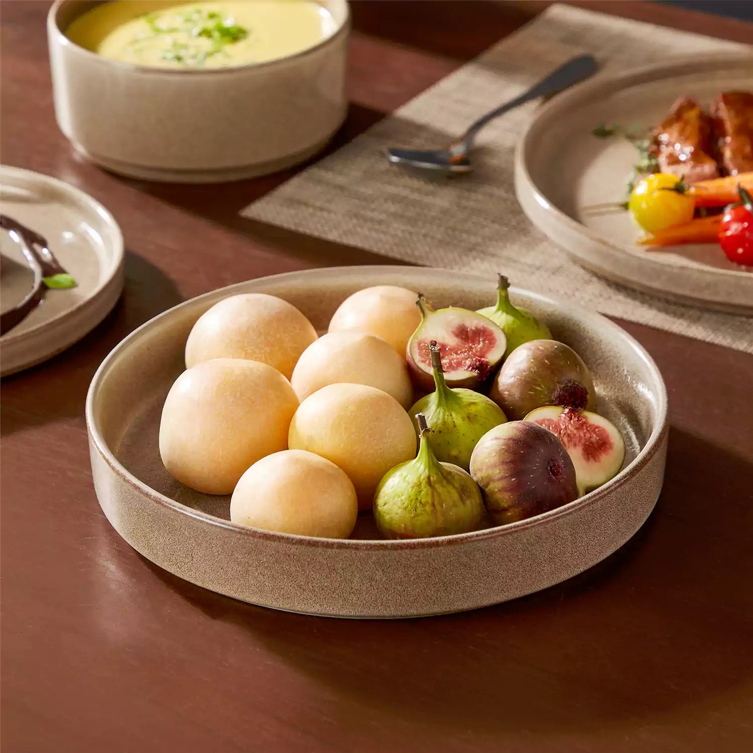 Anya 16 piece straight edge stoneware dinner set in caramel with pasta soup and pastries on a modern farmhouse table