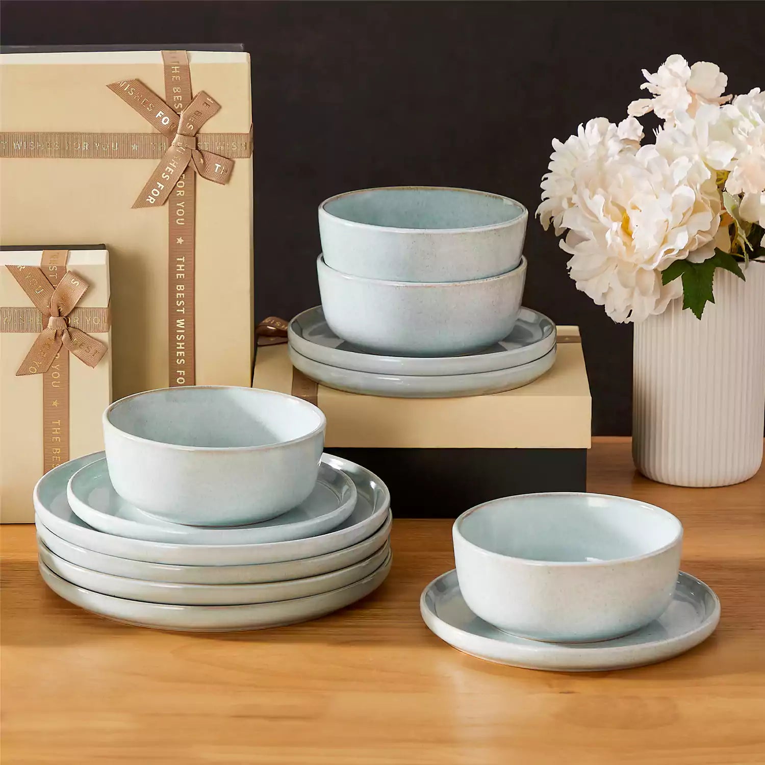 Mint green stoneware plates and bowls with reactive glaze on farmhouse wooden table with woven placemats