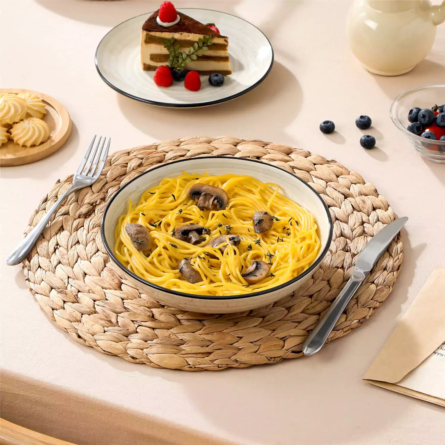 Bonbon stoneware pasta bowls in beige with spiral speckled glaze on a styled dining table