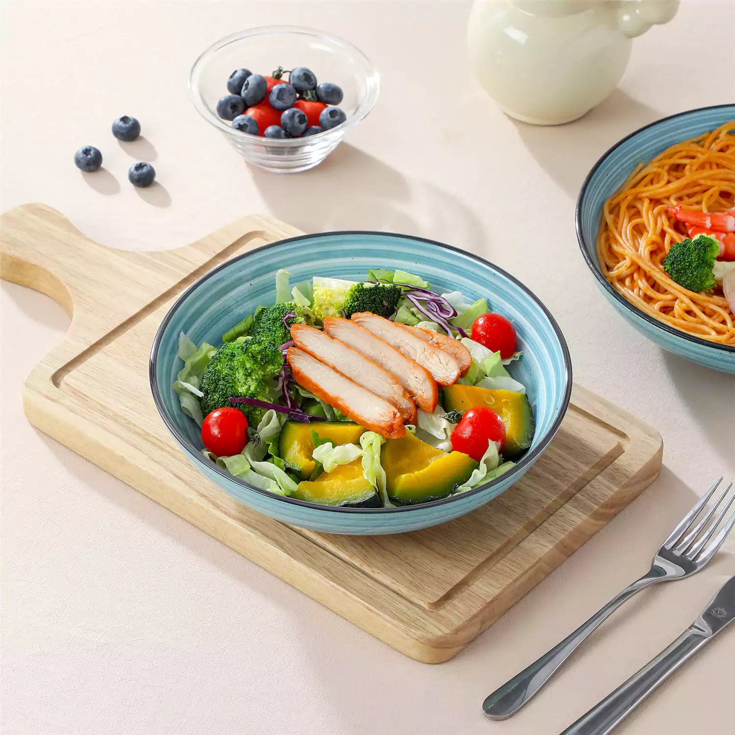 Bonbon stoneware pasta bowls in blue with spiral speckled glaze on a styled dining table