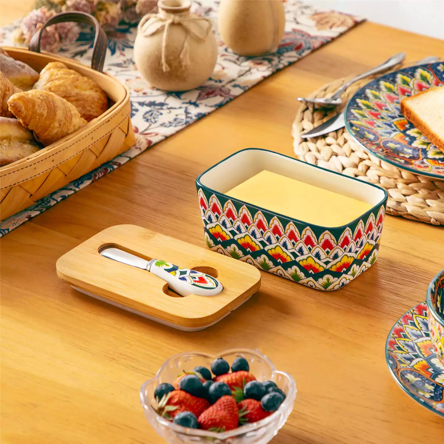 Lumi forest green porcelain butter dish with lid in vibrant Bohemian pattern on a wooden table