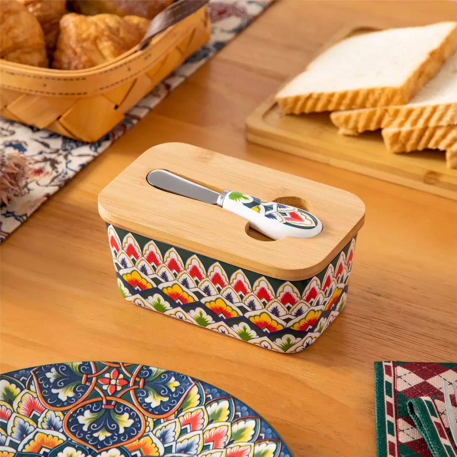 Lumi forest green porcelain butter dish with lid in vibrant Bohemian pattern on a wooden table