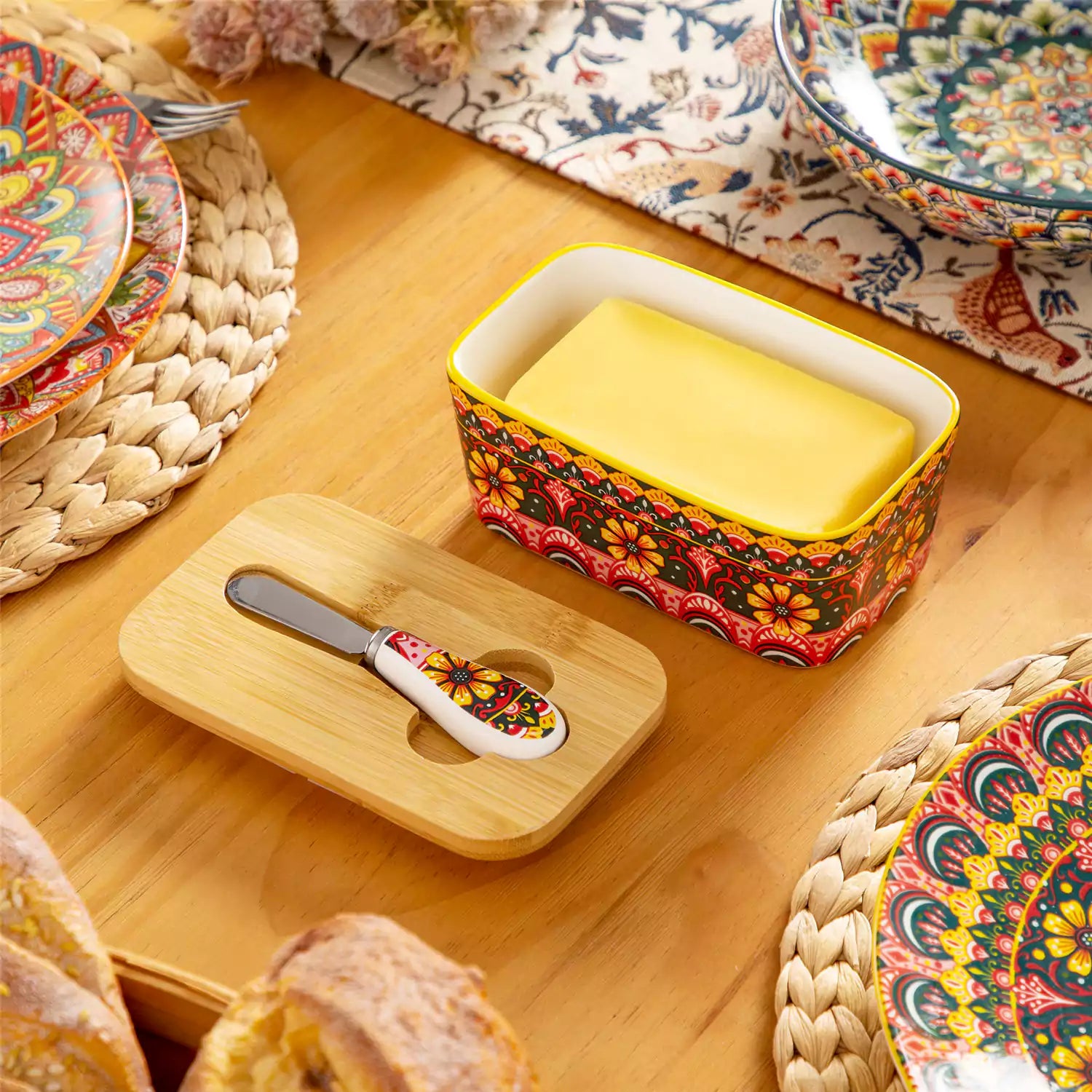 Lumi lemon yellow porcelain butter dish with lid in vibrant Bohemian pattern on a wooden table