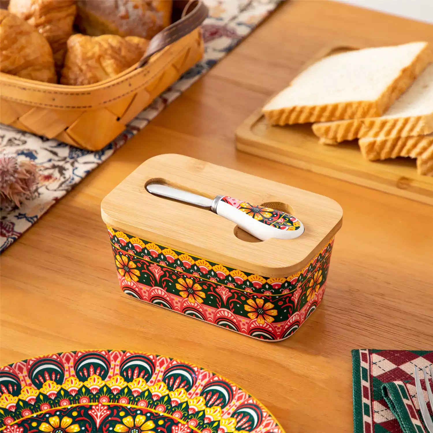 Lumi lemon yellow porcelain butter dish with lid in vibrant Bohemian pattern on a wooden table
