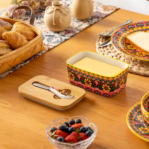Lumi lemon yellow porcelain butter dish with lid in vibrant Bohemian pattern on a wooden table