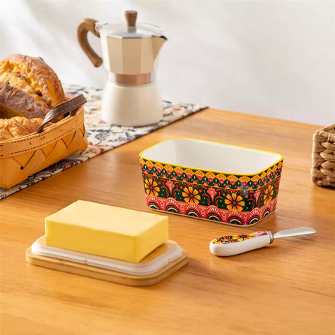 Lumi lemon yellow porcelain butter dish with lid in vibrant Bohemian pattern on a wooden table
