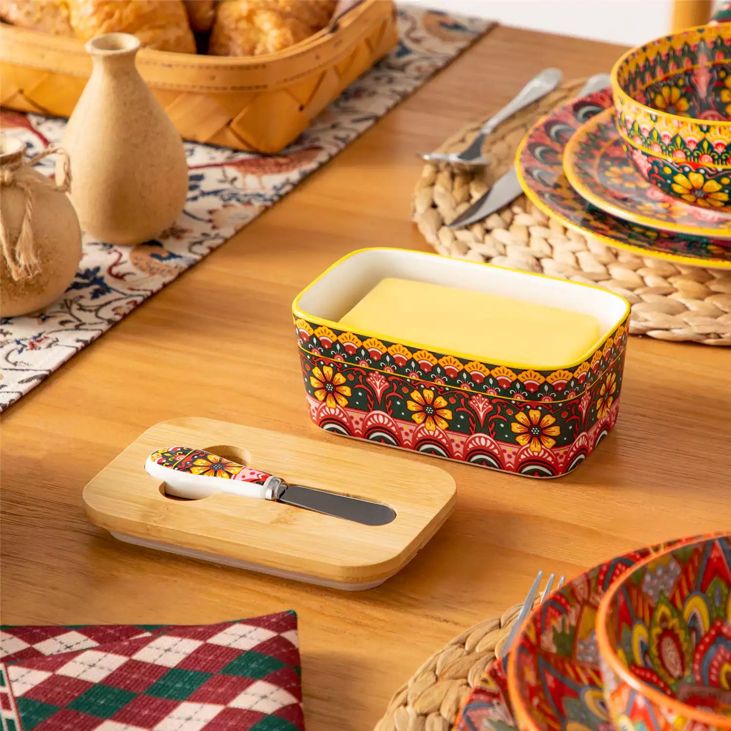 Lumi lemon yellow porcelain butter dish with lid in vibrant Bohemian pattern on a wooden table