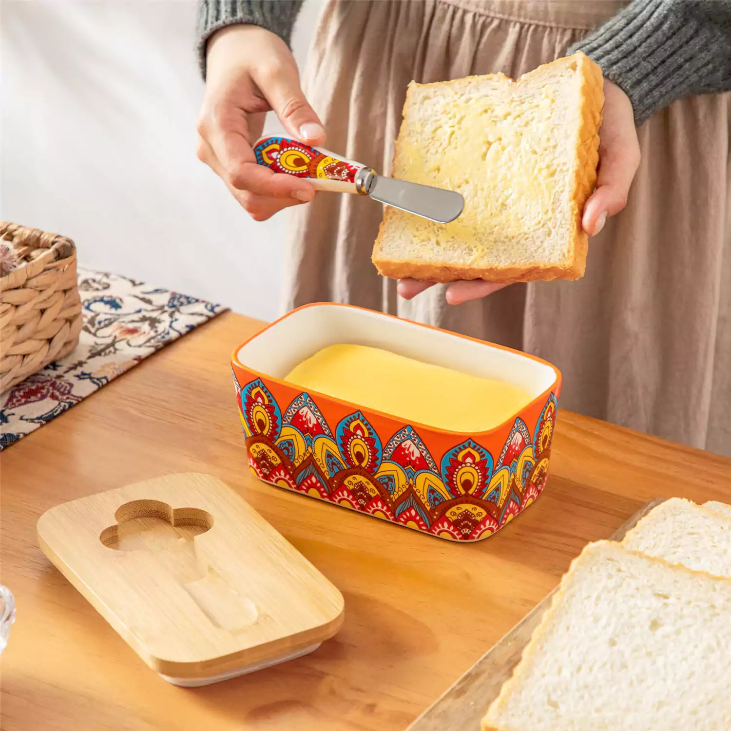 Lumi bold orange porcelain butter dish with lid in vibrant Bohemian pattern on a wooden table