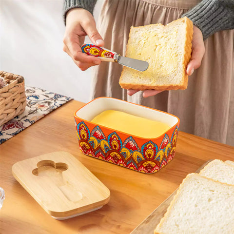 Lumi bold orange porcelain butter dish with lid in vibrant Bohemian pattern on a wooden table
