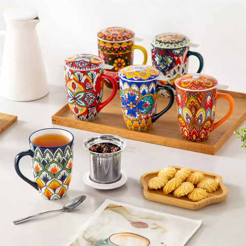 Lumi hunter green porcelain tea mug with infuser and lid featuring vibrant Bohemian pattern on a wooden desk with laptop and plant