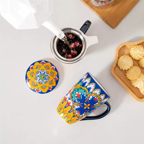 Lumi vibrant blue porcelain tea mug with infuser and lid featuring vibrant Bohemian pattern on a wooden desk with laptop and plant