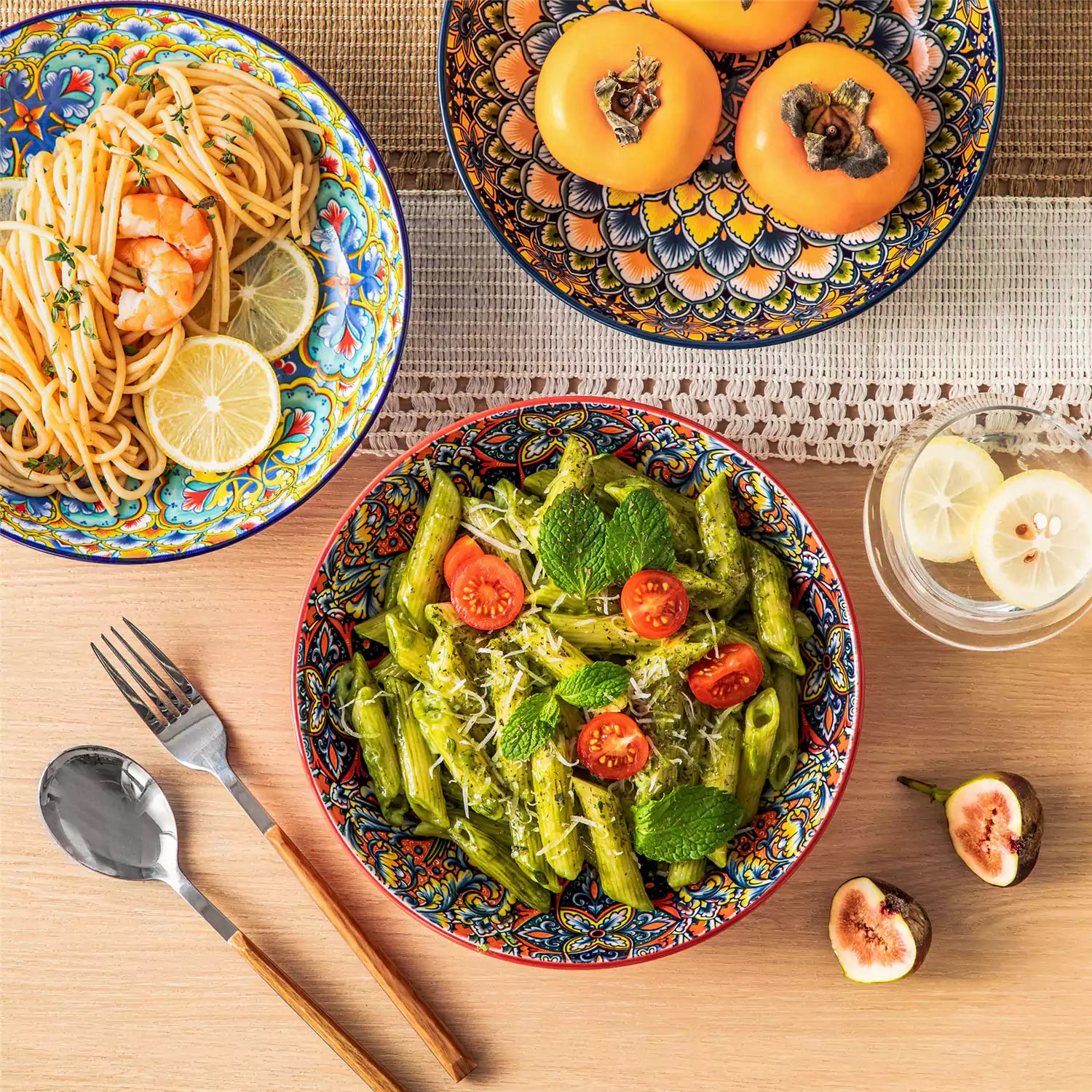 Vibrant Boho pasta bowls on a wooden table filled with pasta cherries and persimmons for a colorful, casual dining setting