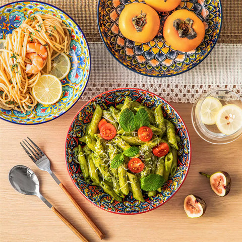 Vibrant Boho pasta bowls on a wooden table filled with pasta cherries and persimmons for a colorful, casual dining setting
