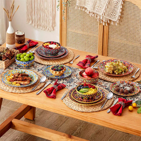 Lumi 12-piece Bohemian dinnerware set for 4 with colorful patterned plates and bowls on a wooden Boho dining table with food