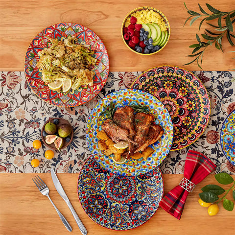 Lumi 12-piece Bohemian dinnerware set for 4 with colorful patterned plates and bowls on a wooden Boho dining table with food
