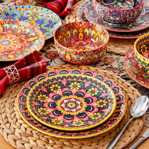 Lumi 12-piece Bohemian dinnerware set for 4 with colorful patterned plates and bowls on a wooden Boho dining table with food