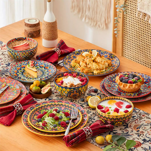Lumi 18-piece Bohemian dinnerware set for six on a wooden table with colorful plates bowls and silverware in a playful Boho style