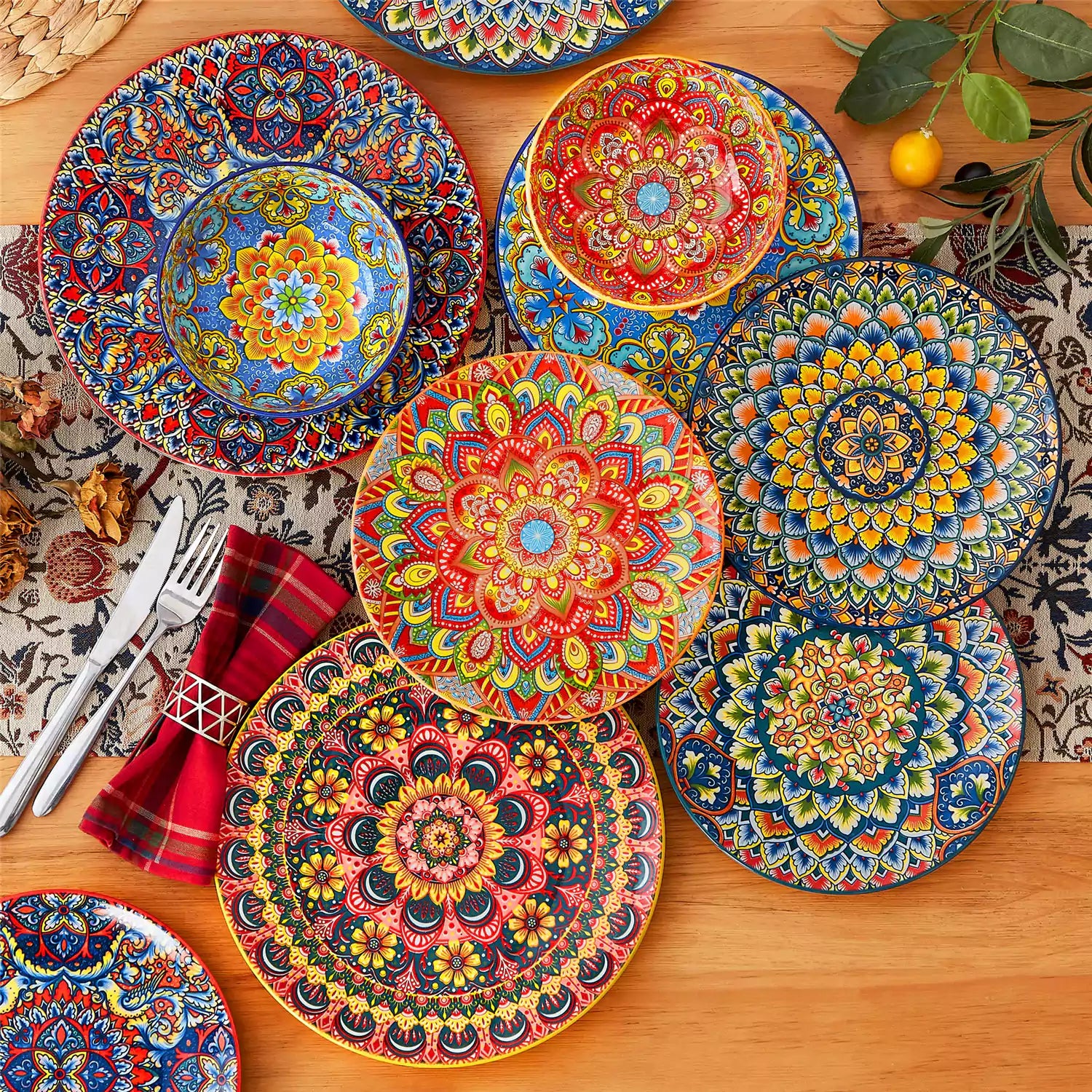 Lumi 18-piece Bohemian dinnerware set for six on a wooden table with colorful plates bowls and silverware in a playful Boho style