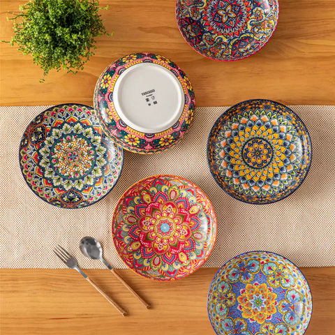 Vibrant Lumi porcelain pasta bowls filled with fruit salad pumpkin soup and pasta on a wooden dining table