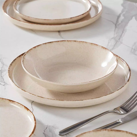 Plays 24-piece stoneware dinnerware set with pasta - soup - and fruit waffle on marble table - featuring sandy speckled plates and bowls with brown rims-vancasso