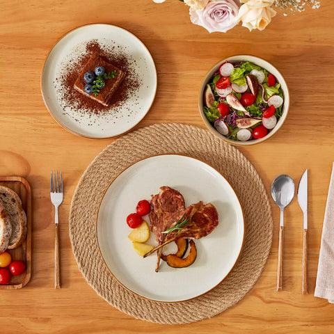 Beige rustic stoneware dinnerware set with speckled - lipped-edge plates and bowls on a dining table with flowers and cutlery in a cozy modern kitchen-vancasso