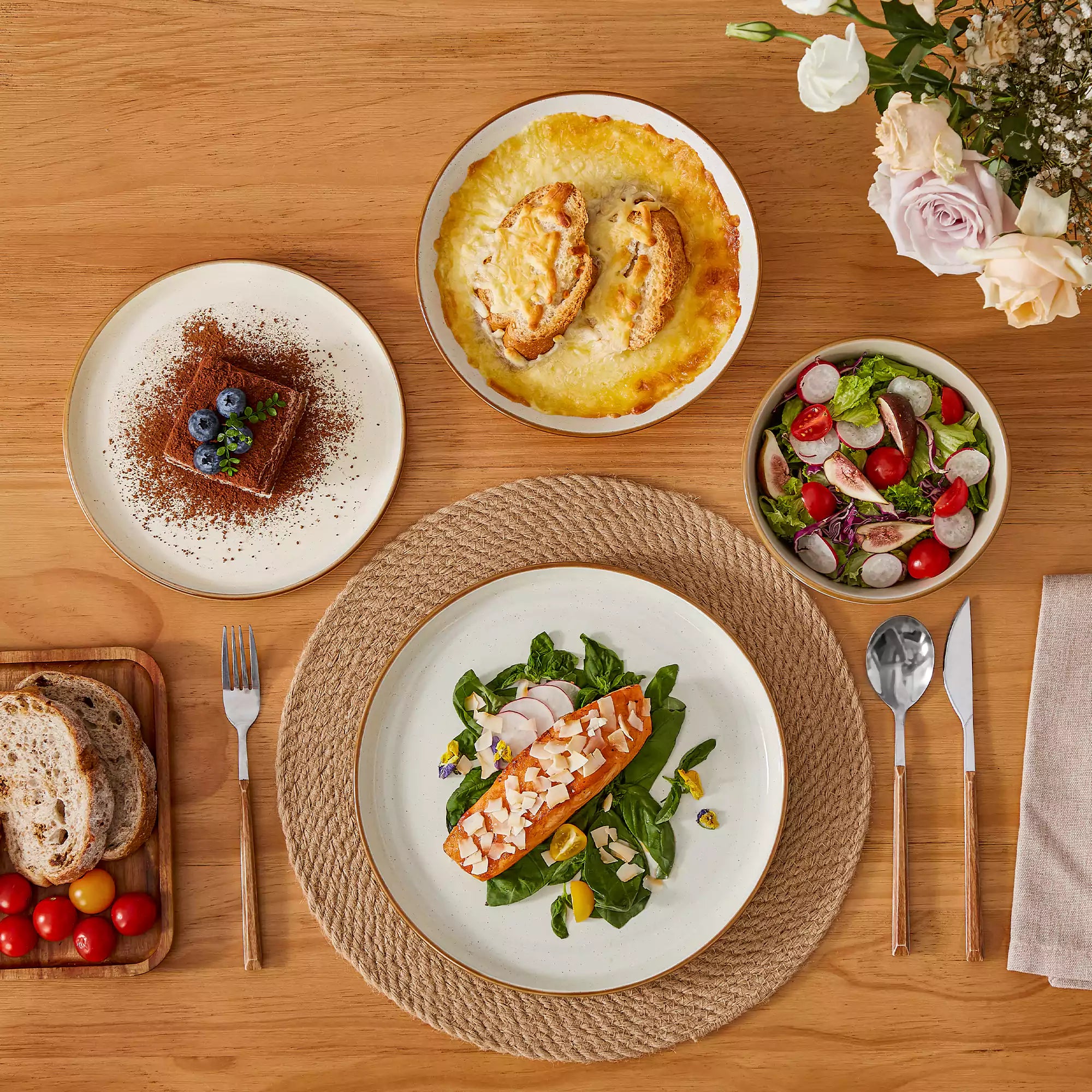 Rustic beige speckled stoneware dinnerware set with lipped-edge plates and bowls arranged on a sunlit modern dining table-vancasso