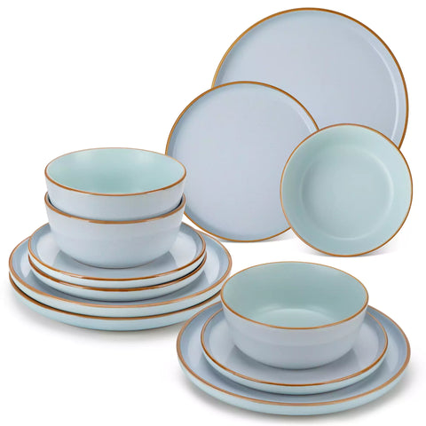 Blue rustic stoneware dinnerware set with speckled - lipped-edge plates and bowls on a dining table with flowers and cutlery in a cozy modern kitchen-vancasso