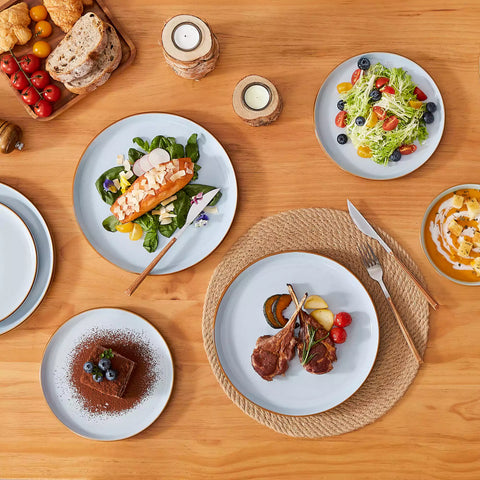 Blue rustic stoneware dinnerware set with speckled - lipped-edge plates and bowls on a dining table with flowers and cutlery in a cozy modern kitchen-vancasso
