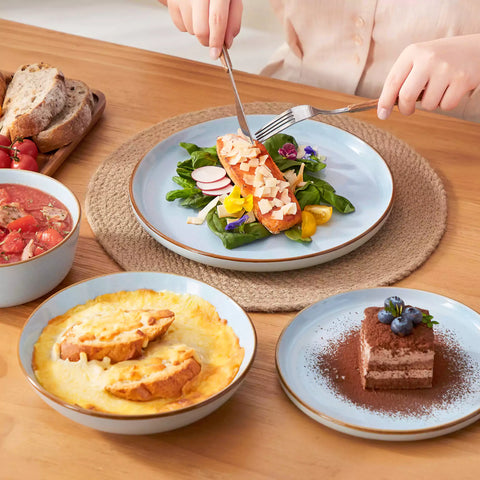 Rustic blue speckled stoneware dinnerware set with lipped-edge plates and bowls arranged on a sunlit modern dining table-vancasso