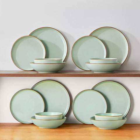 Rustic green speckled stoneware dinnerware set with lipped-edge plates and bowls arranged on a sunlit modern dining table-vancasso