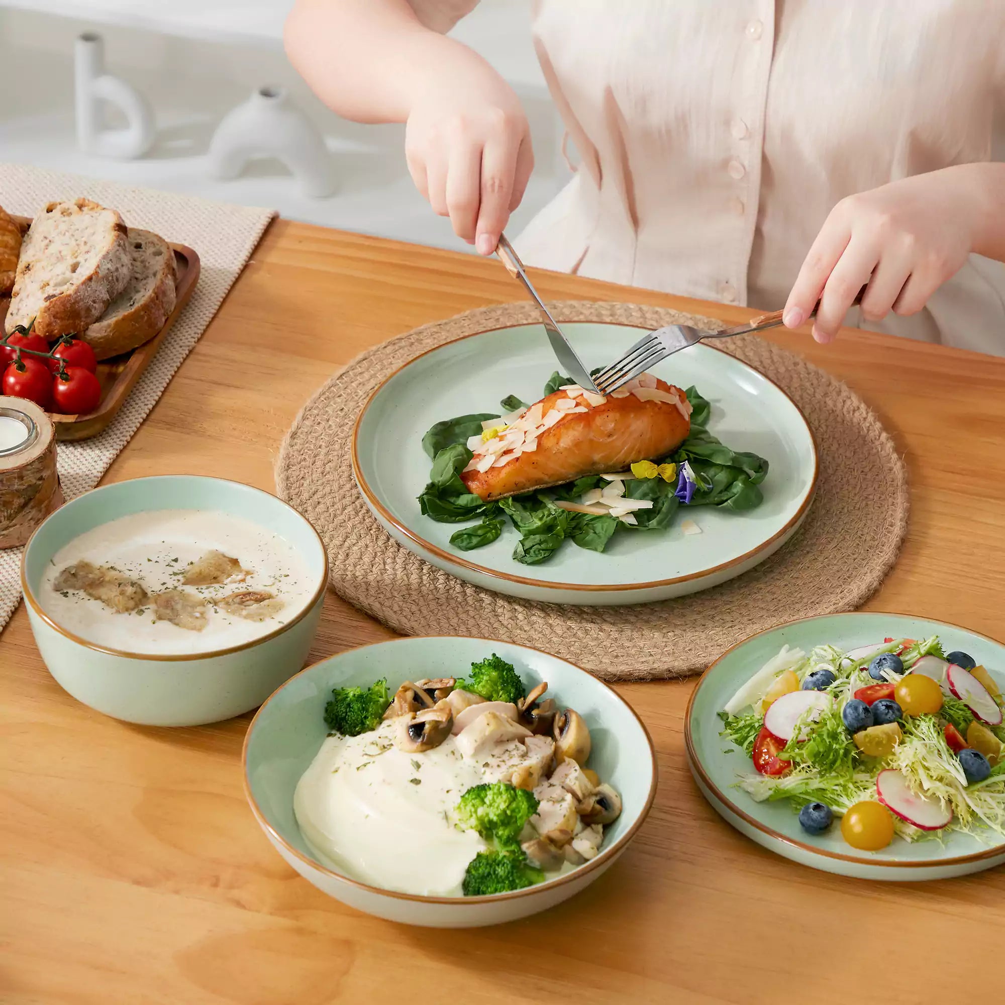 Rustic green speckled stoneware dinnerware set with lipped-edge plates and bowls arranged on a sunlit modern dining table-vancasso