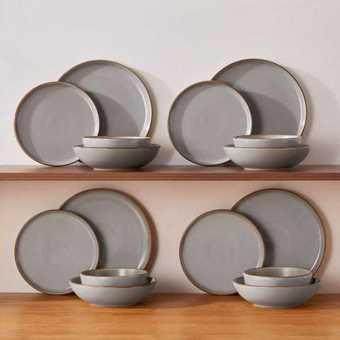 Rustic grey speckled stoneware dinnerware set with lipped-edge plates and bowls arranged on a sunlit modern dining table-vancasso