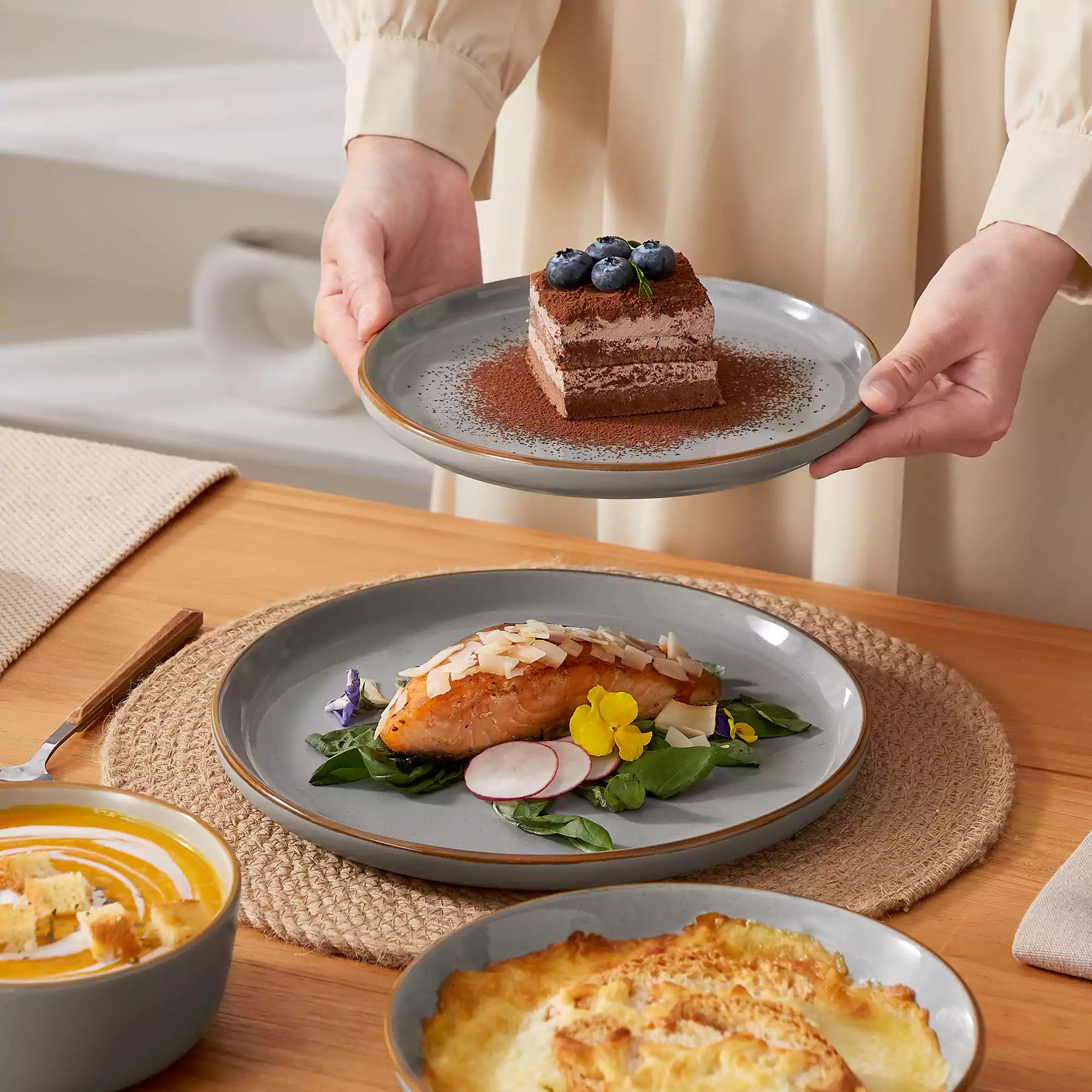 Rustic grey speckled stoneware dinnerware set with lipped-edge plates and bowls arranged on a sunlit modern dining table-vancasso